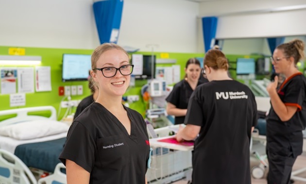 Nursing student looking at camera in nursing suite