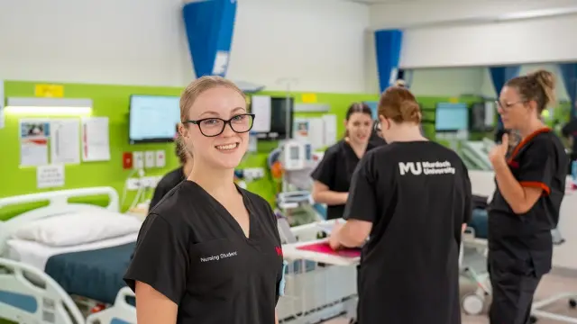 Nursing student looking at camera in nursing suite