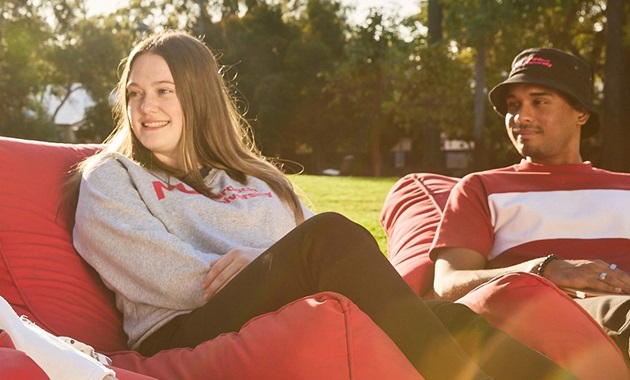 Students sitting together while laughing on beanbags located on Bush Court