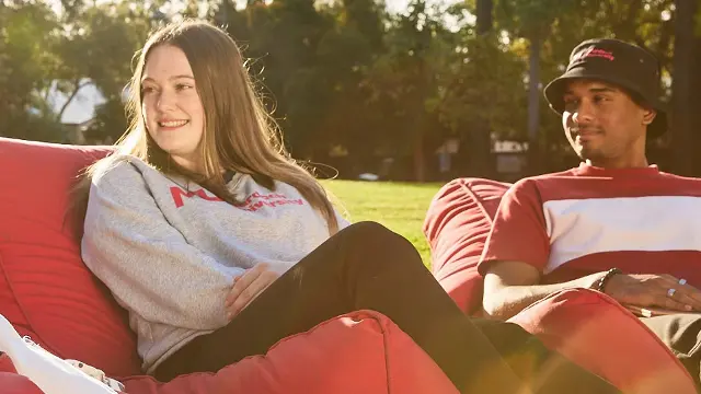 Students sitting together while laughing on beanbags located on Bush Court