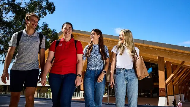 Group of students walking with Boola Katijin building in the background