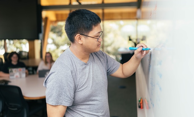Student writing on whiteboard