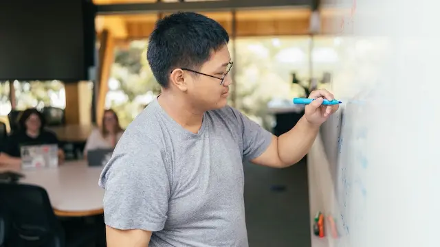 Student writing on whiteboard