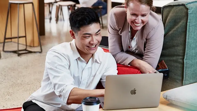 Murdoch University students looking at laptop