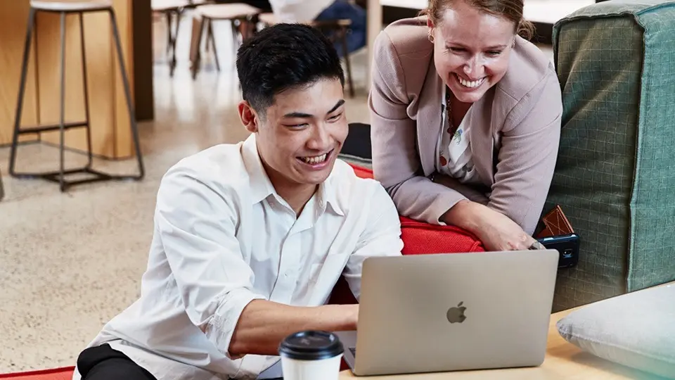 Murdoch University students looking at laptop