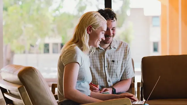 Murdoch University students looking at laptop