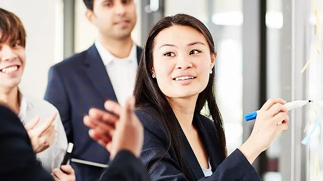 Murdoch University student business writing on whiteboard