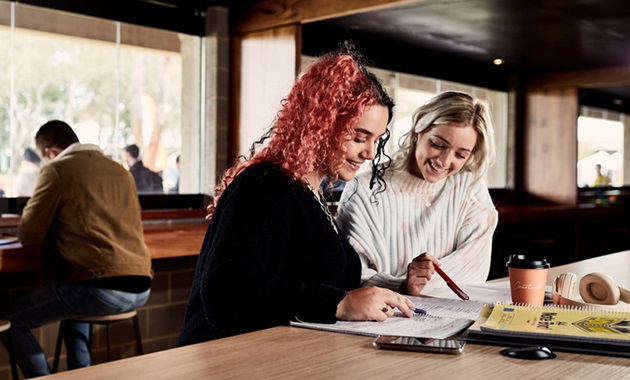 2 female students looking at notes