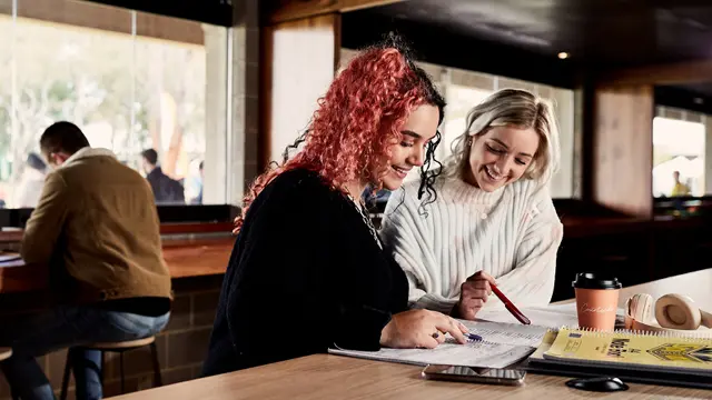 2 female students looking at notes