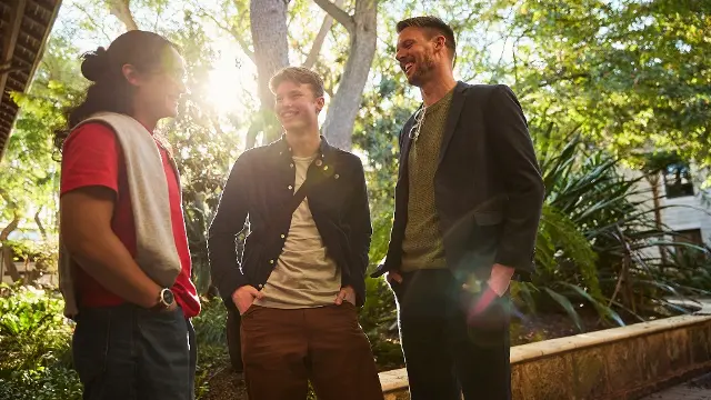 Three students standing in sunlight