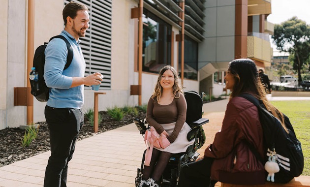 3 students talking on campus