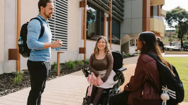3 students talking on campus