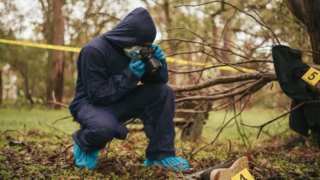 Murdoch University forensic student wearing overalls, inspecting scene