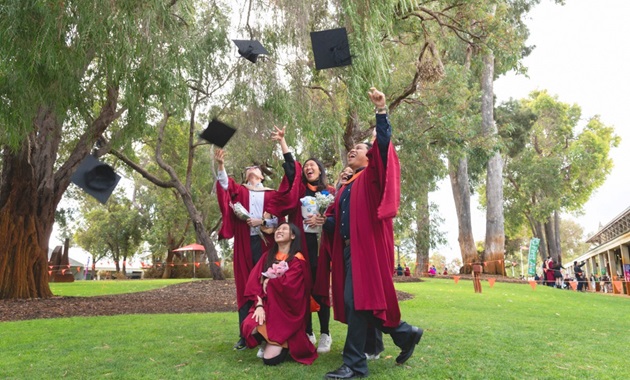 Graduation image of students throwing caps