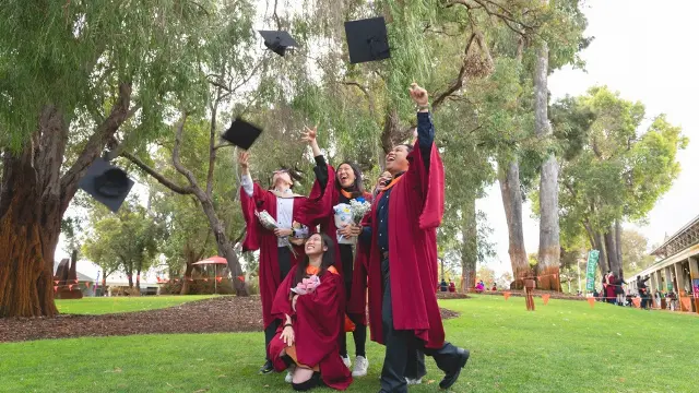 Graduation image of students throwing caps