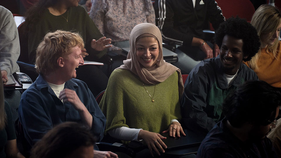 Law student smiling with classmates in a Murdoch lecture theatre