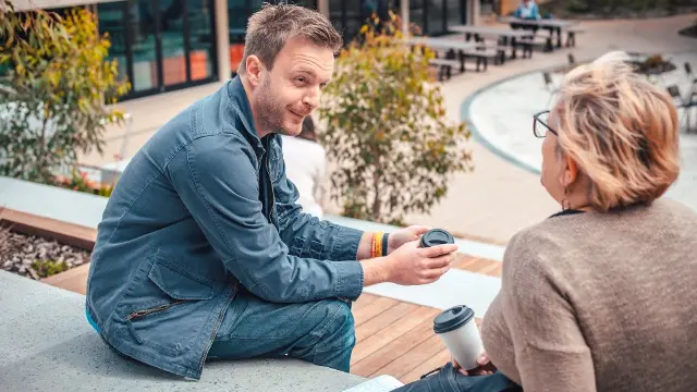 Mature age students talking in the winter garden.