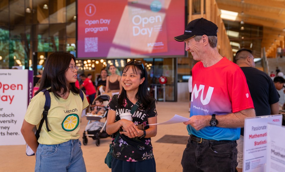 Two female potential students talking to a university representative