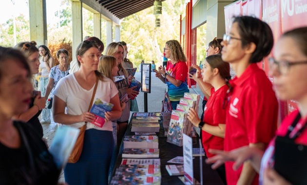 visitors talking to university representatives