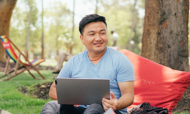 Student sitting on beanbag with laptop on Bush Court