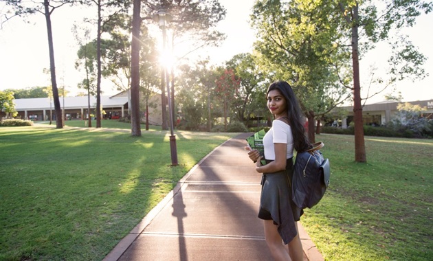 Student walking on path at Bush Court.