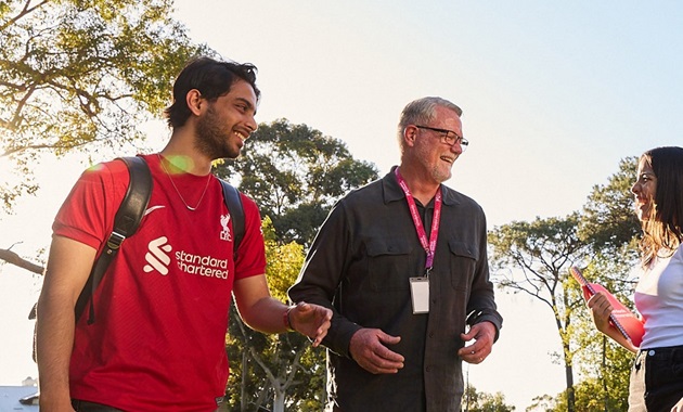 Staff and two students laughing together on Bush Court