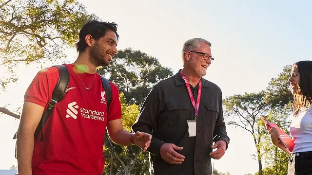 Staff and two students laughing together on Bush Court