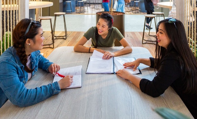 Three Study Abroad students working together in the Student Hub.