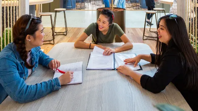 Three Study Abroad students working together in the Student Hub.