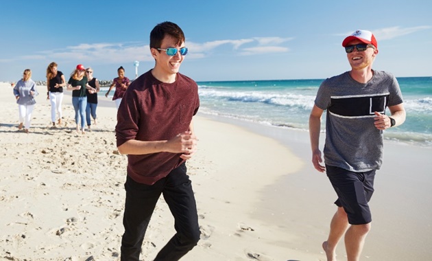 A group of Study Abroad students walking along the beach.