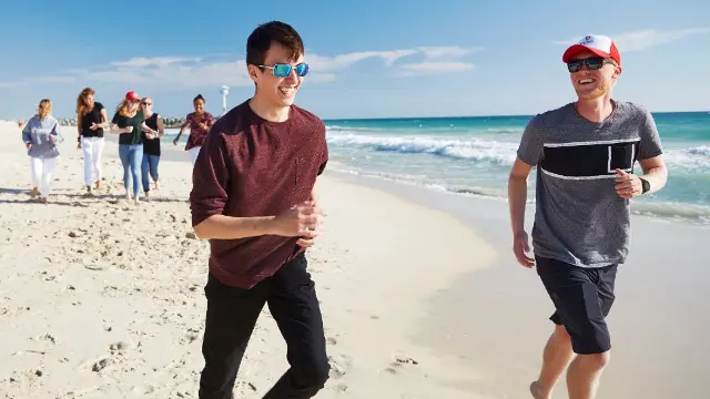 A group of Study Abroad students walking along the beach.