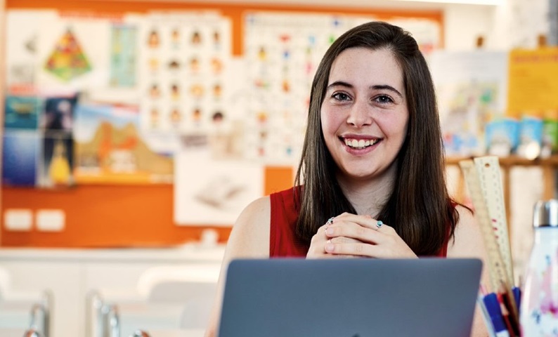 Teaching student at desk.