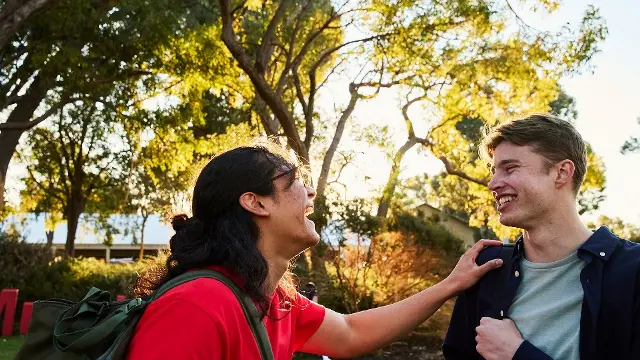 Two students laughing together on Bush Court