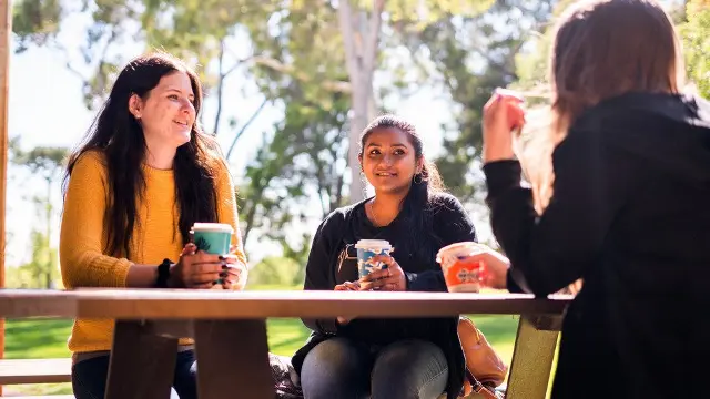 students sitting at picnic table