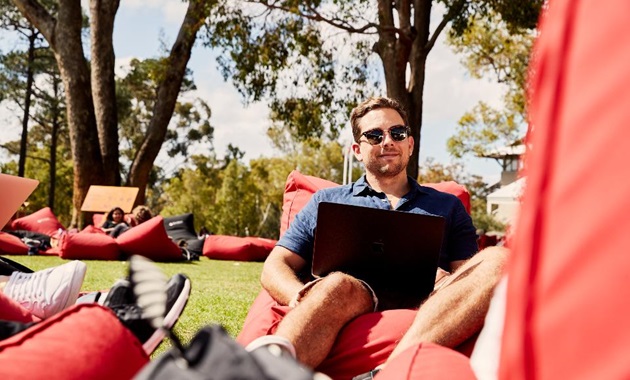 student sitting outside with laptop