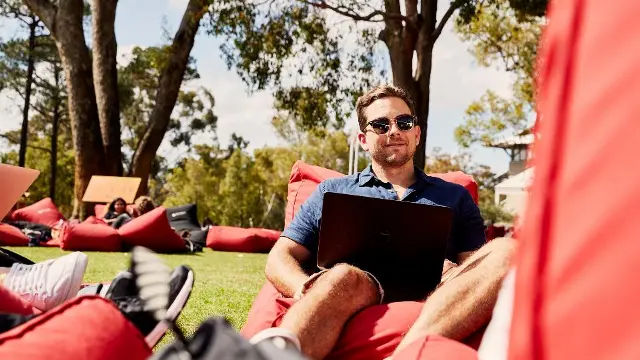 student sitting outside with laptop