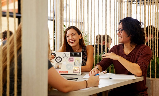 male and female student discussing and laughing