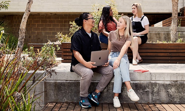 male and female student talking to each other with 2  female in background