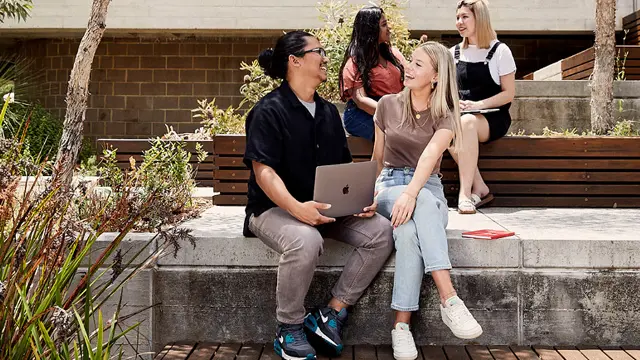 male and female student talking to each other with 2  female in background