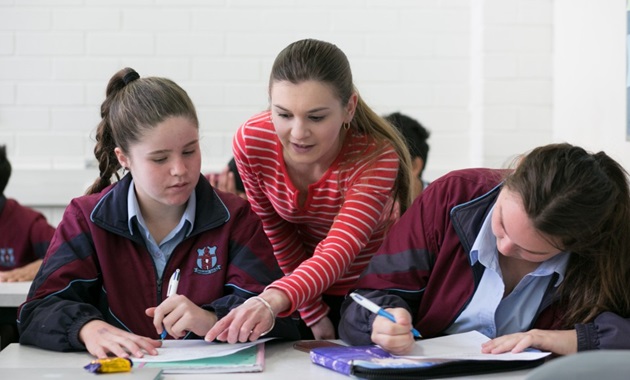 High school teacher with students in the classroom.