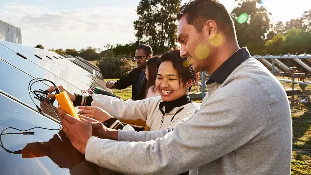People standing near solar panels