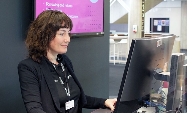 Librarian at help desk using computer