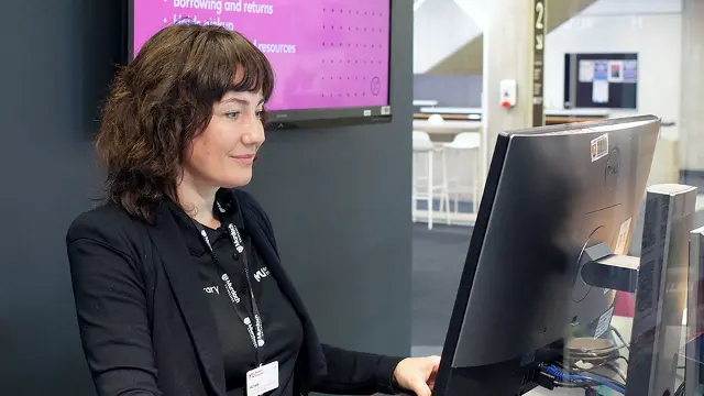 Librarian at help desk using computer