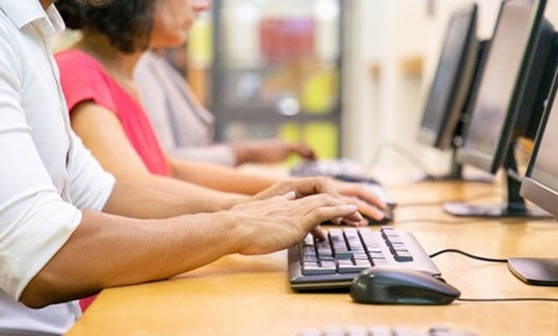 People typing at desktop computers