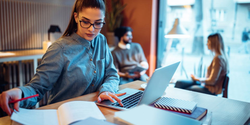 Person sitting at a table with laptop studying