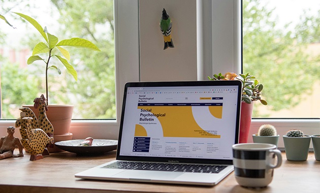 An open laptop on a desk displaying a journal article