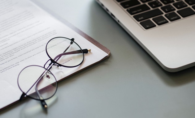 Eye glasses next to a laptop