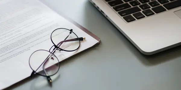 Eye glasses next to a laptop