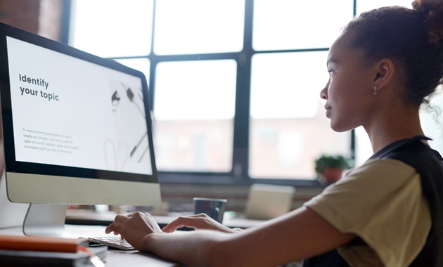 A woman at computer with "Identify your topic" written on the screen