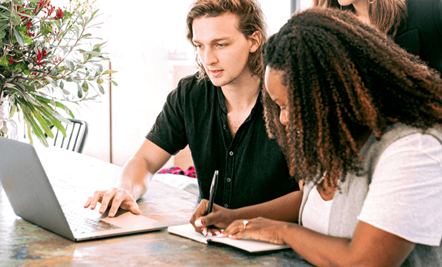 Group of students collaborating toghether at laptop